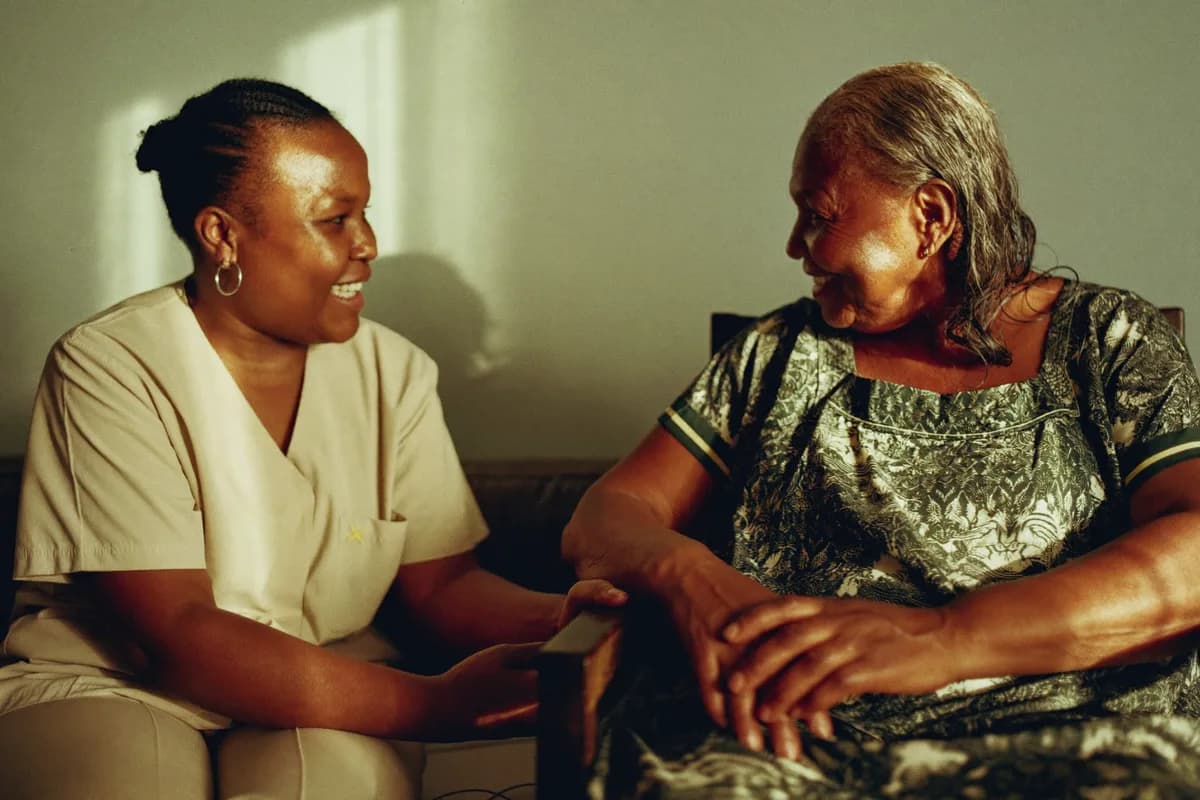 A carer and an older woman together at home in Nigeria