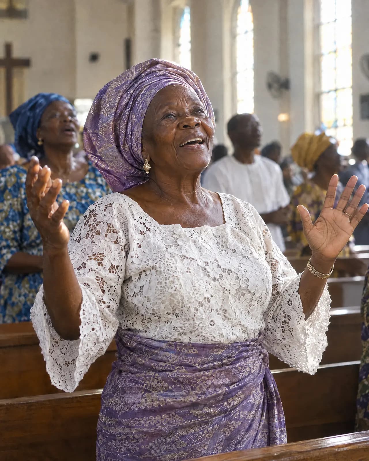 An older woman singing with her hands raised in church