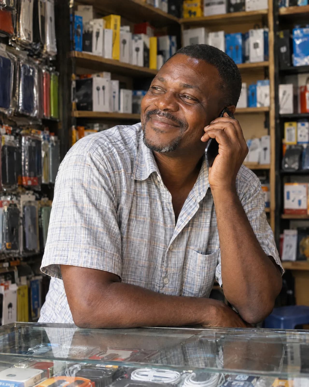 A man in his shop on the phone, quietly touched